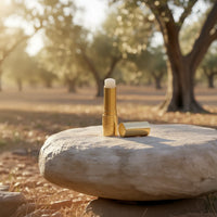 Rustic | The rough stone and sunlit olive grove evoke a rustic and earthy atmosphere.
